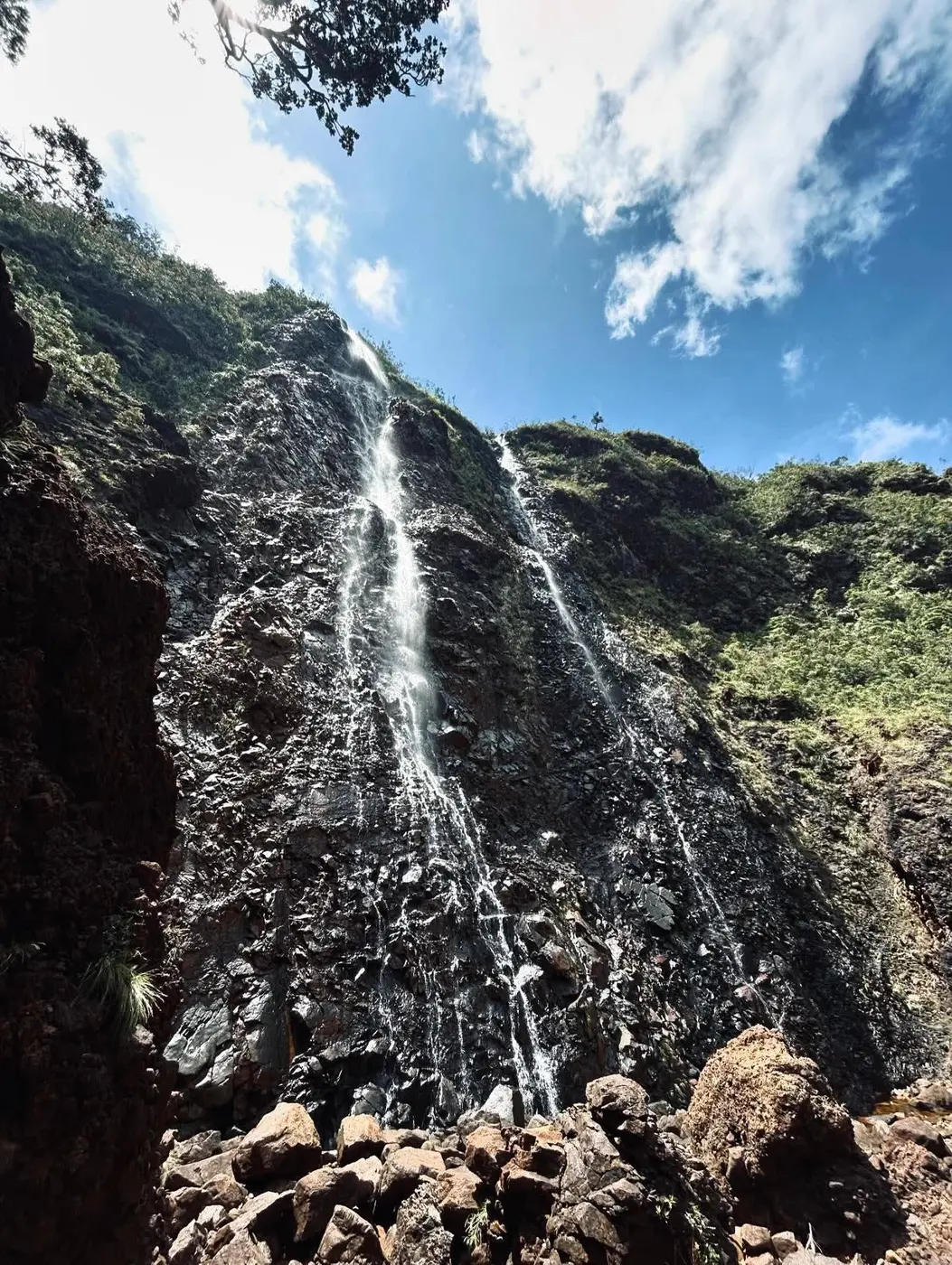 A tall waterfall streaming down dark rock
